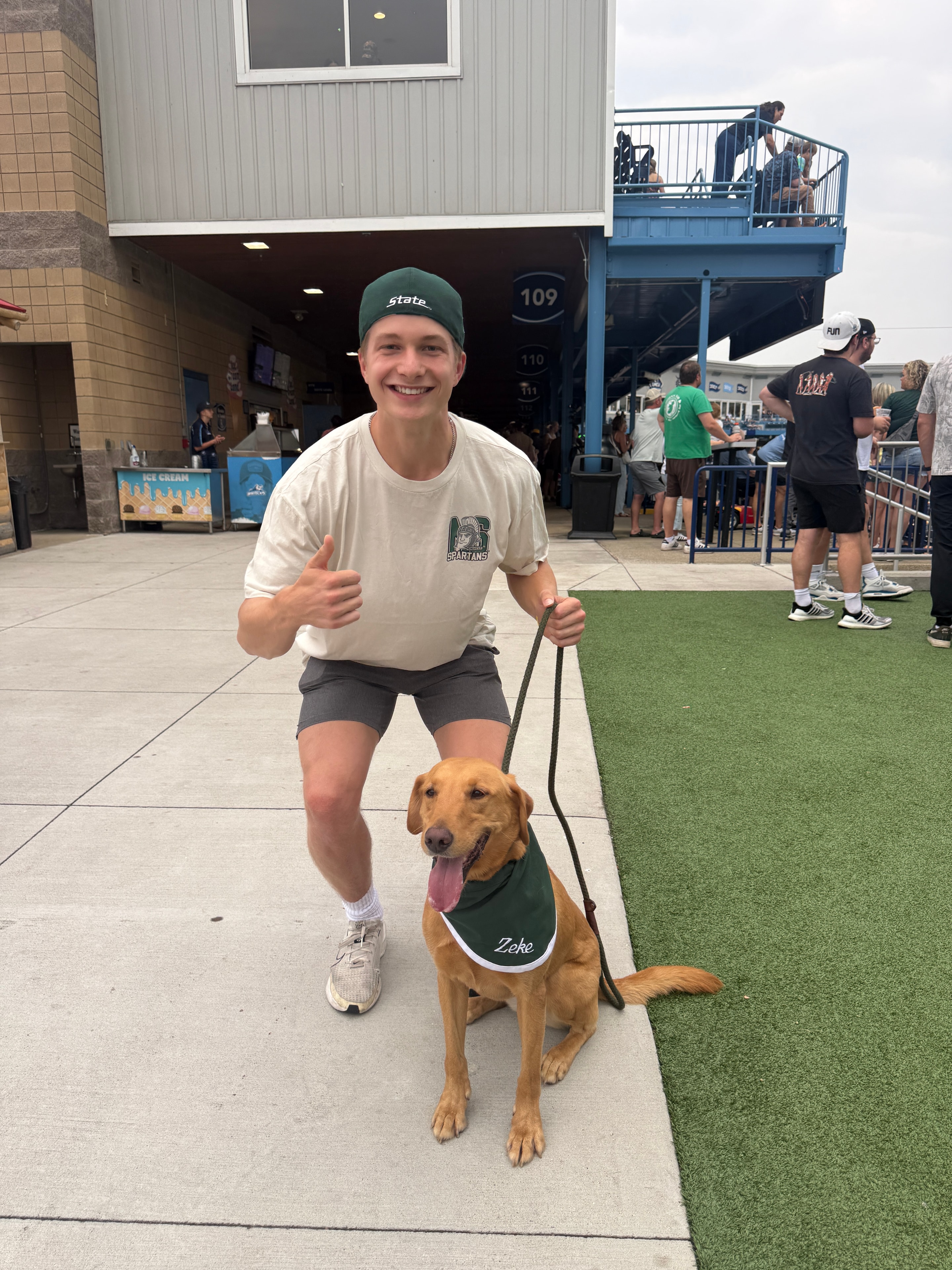 Zeke and handler walking at LMCU Ballpark